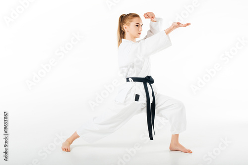 girl in kimono training karate isolated on white