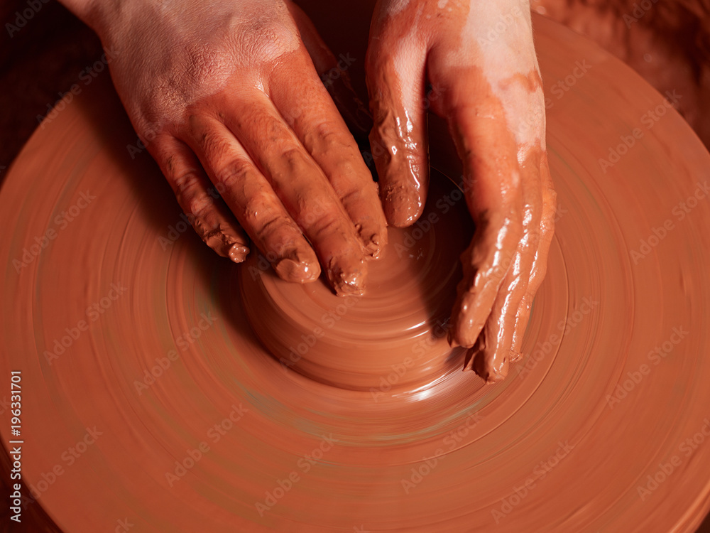 production process of pottery. Forming the clay cover of the kettle on the potter's wheel.