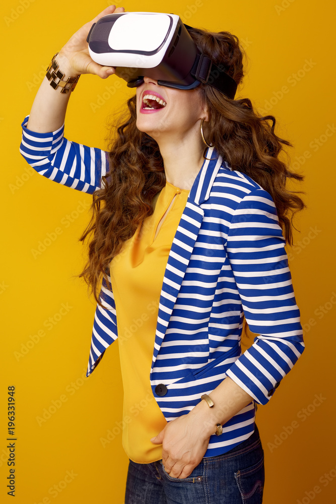 smiling woman on yellow background wearing virtual reality gear smiling woman on yellow background wearing virtual reality gear
