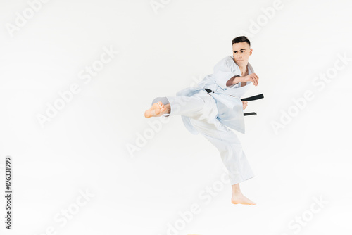 Male karate fighter training isolated on white