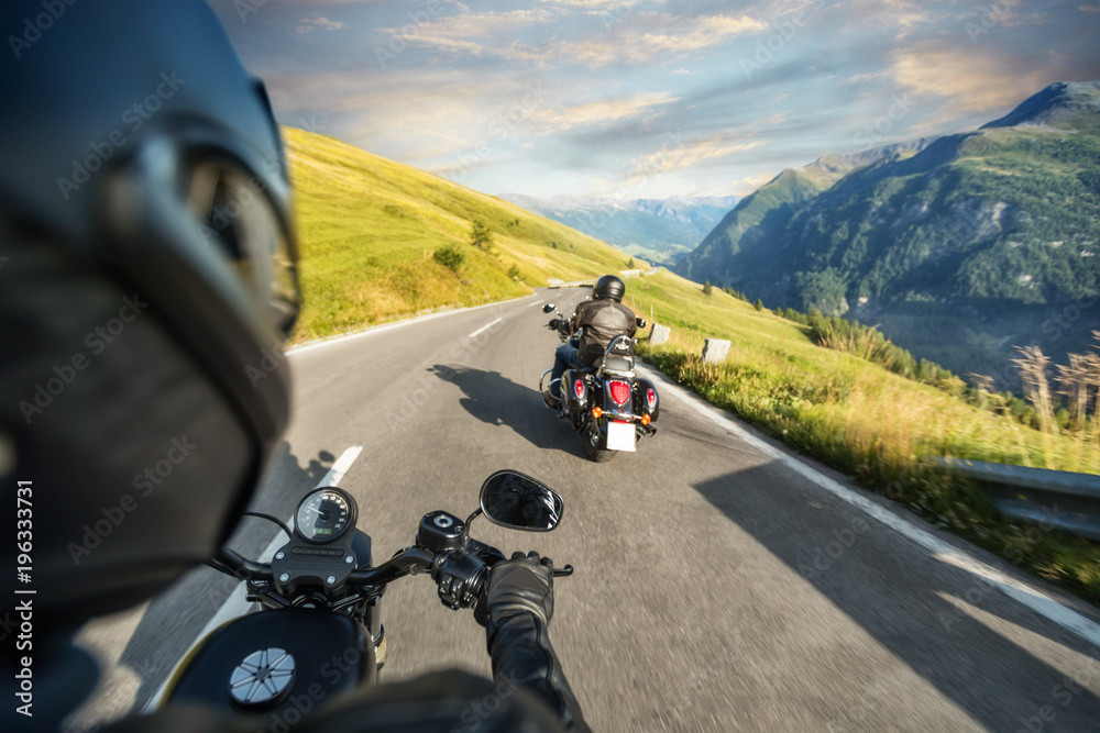 POV of motorbiker holding steering bar, riding in Alps POV of motorbiker holding steering bar, riding in Alps