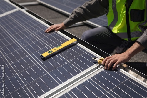 Male worker working on solar panels at solar station photo