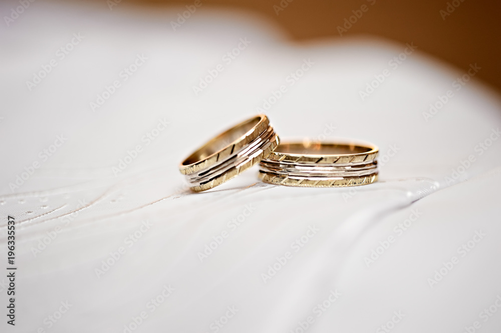Two isolated golden wedding rings on white background