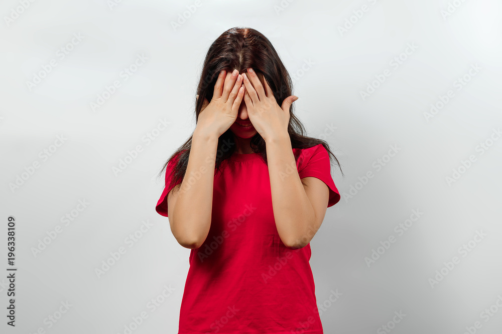 Young, beautiful girl, covers her face with her hands. Isolated on a light background. Different human emotions, feelings of facial expression, attitude, perception, body language, reaction. Young, beautiful girl, covers her face with her hands. Isolated on a light background. Different human emotions, feelings of facial expression, attitude, perception, body language, reaction.