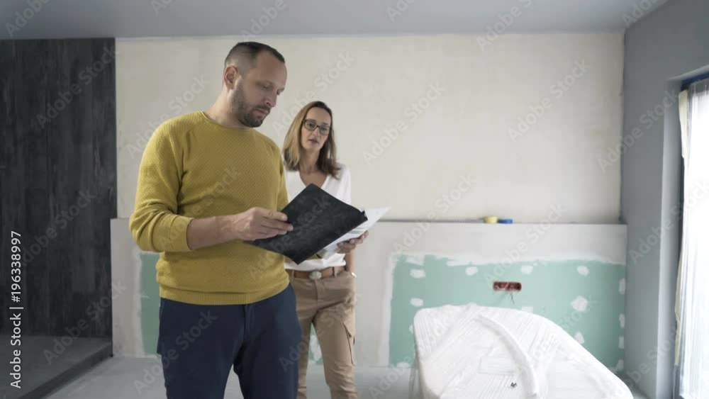 Young couple talking and checking documents at their new home
Young couple talking and checking documents at their new home