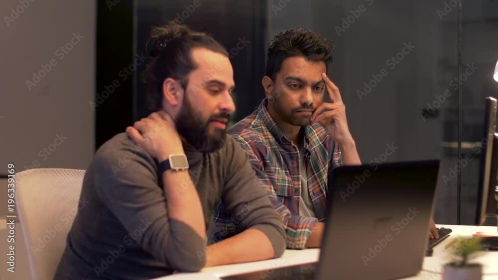 creative team with computer working late at office creative team with computer working late at office