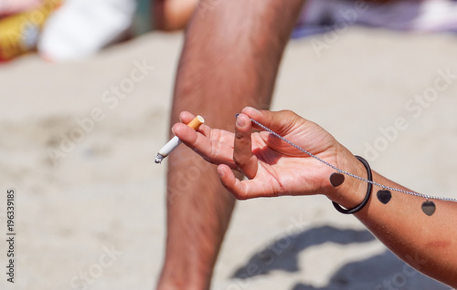 Smoking with cigarette butts ashtray on the sand on the beach and travel activity