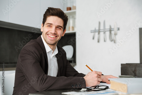 Happy young businessman working indoors