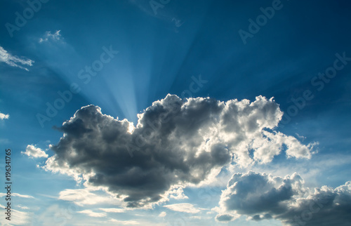 Sun rays against a blue sky in the clouds