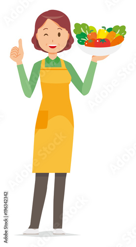 A middle-aged housewife wearing an apron has vegetables