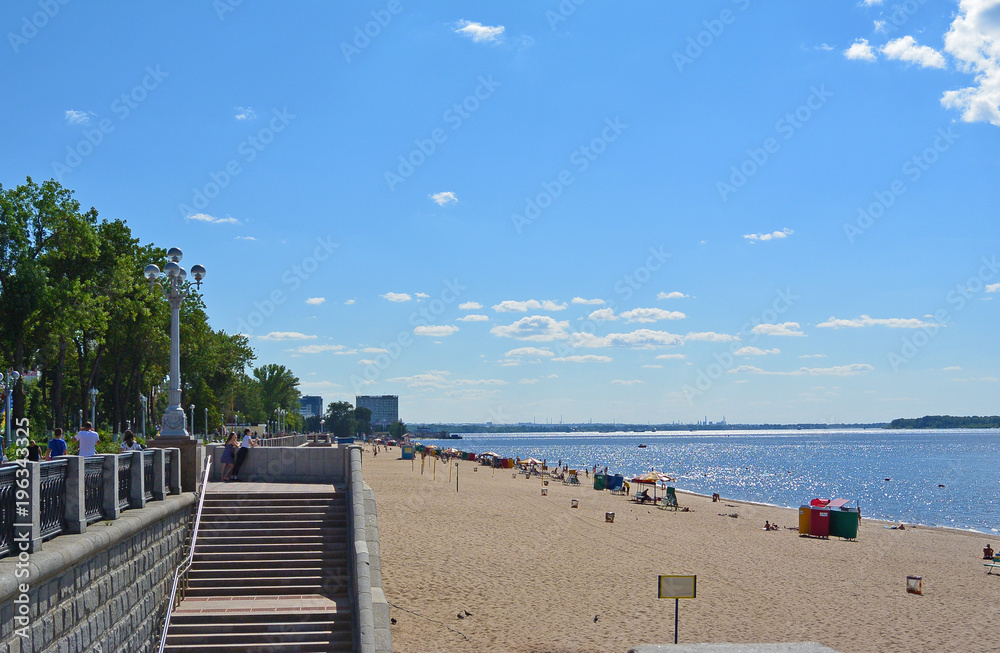 Samara, people on city beach on the shores of the Volga River. beautiful cumulus clouds on blue sky