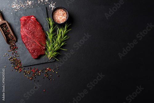 Raw beef steak on dark concrete table. Top view