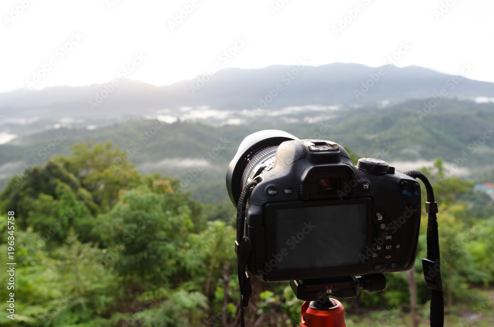 DSLR Camera set on camera tripod for take a landscape photo in selective focus. DSLR Camera set on camera tripod for take a landscape photo in selective focus.