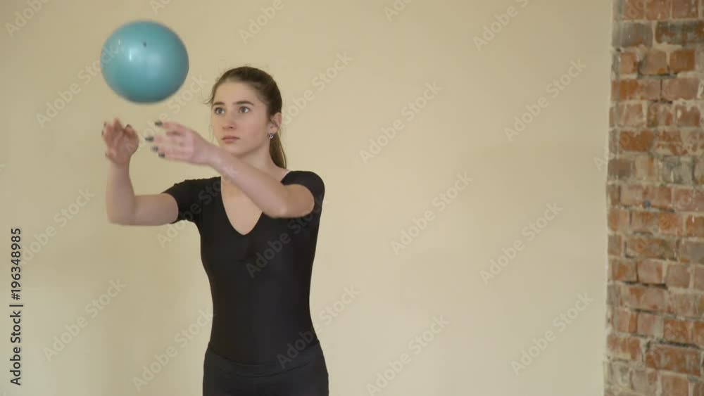 sport gymnastics. fitness lifestyle. calisthenics ball practice. exercise training balance perfecting. young beautiful teen girl in a gym