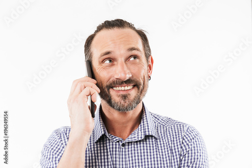 Cheerful adult man talking by mobile phone.