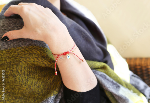 woman wearing the traditional greek martaki bracelet with evil eye - symbol of protection