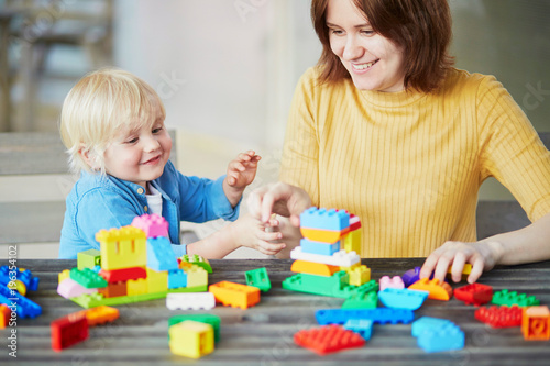 Mother playing colorful construction blocks with her son