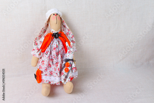 a toy rabbit in a French white dress with flowers and a beret on her head