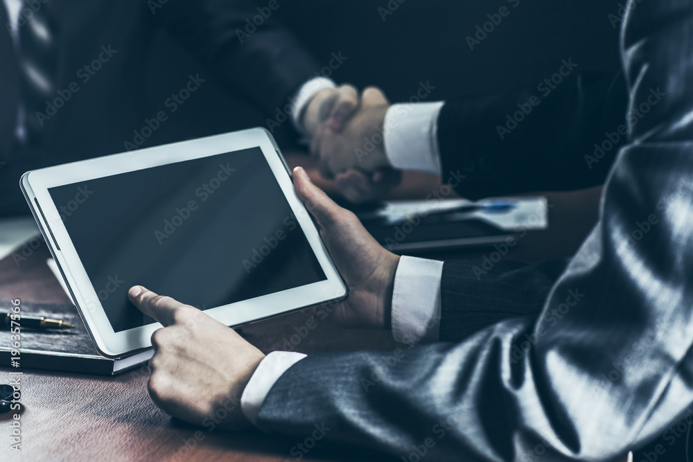 custom made wallpaper toronto digitalcloseup of businessman with digital tablet in the background of handshake of business partners.