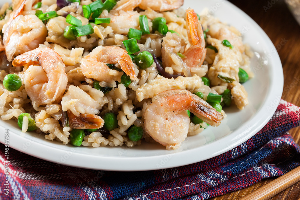 Fried rice with shrimp and vegetables served on a plate Fried rice with shrimp and vegetables served on a plate