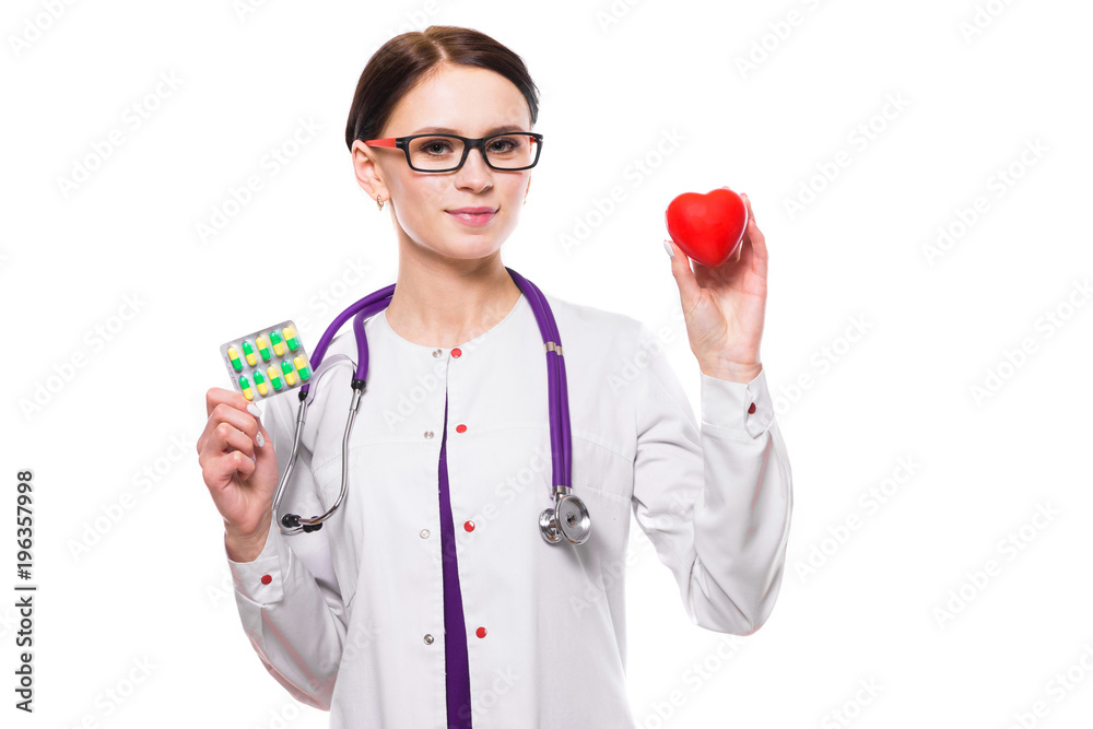 Young beautiful female doctor holding heart and pills in her hands on white background Young beautiful female doctor holding heart and pills in her hands on white background