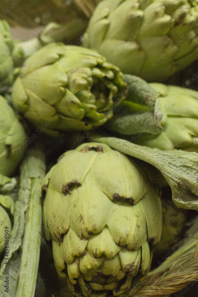 Obraz premium green artichokes over basket