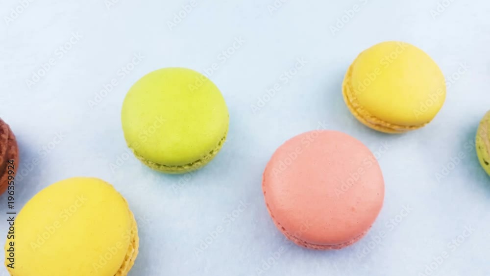 Sweet color macaroons or macaron on pastel blue surface. Close up.