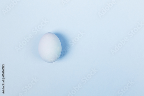 Blue egg on blue background. Top view, copy space. Food background