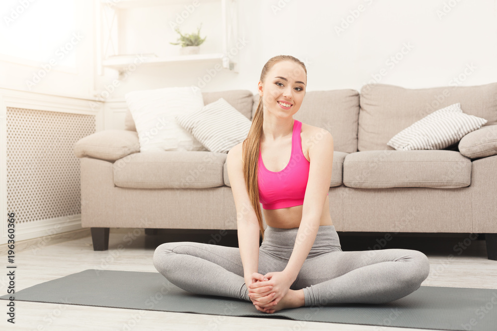 Happy woman training yoga in butterfly pose