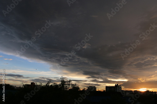 sunset and big black clouds in sky before rain in city, beautiful sunset city landscape , romantic screen