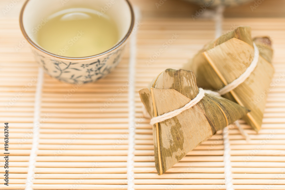 Zongzi or Traditional Chinese Sticky Rice Dumplings on Wooden Placemat Zongzi or Traditional Chinese Sticky Rice Dumplings on Wooden Placemat