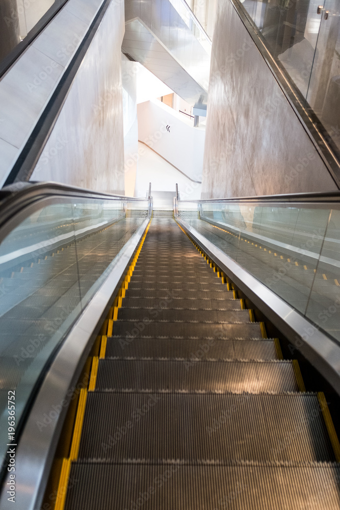 Escalators running down in a white building Escalators running down in a white building