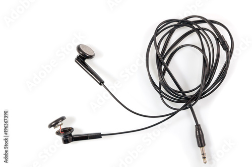 Top view of broken old black earphones or headphones on white background.