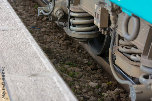 Horizontal View of Close Up of the Shock Absorbers of the Wheels of a Train Wagon Near the Dock at the Railway Station