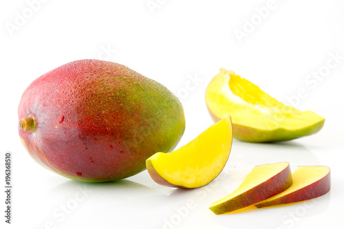 Ripe juicy and appetizing mango fruit and its parts with water drops close-up