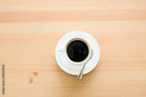 Cup of hot coffee amaricano on the surface placed on the wooden table.