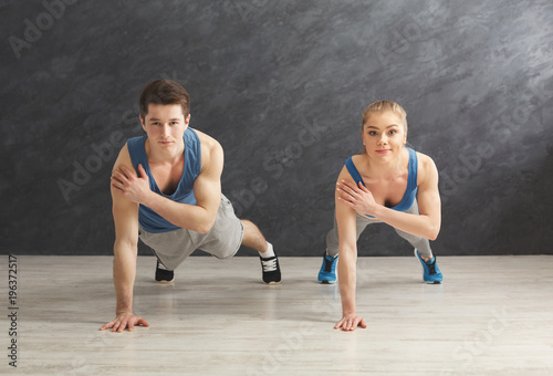Couple making plank or push ups exercise indoors