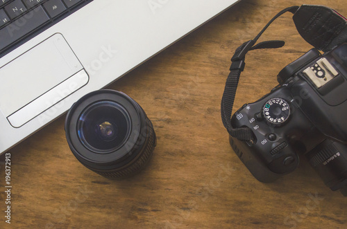 creative environment with a laptop, camera on a wooden table
