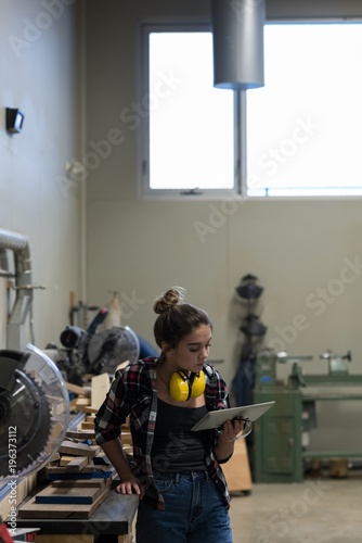 Female carpenter using digital tablet photo