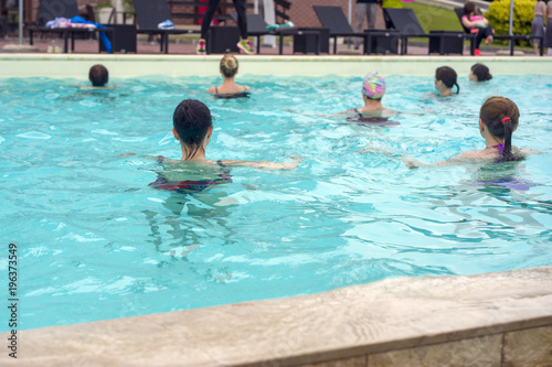 A group of people swim and exercise in the pool, improving the human body, motor activity in the water for health