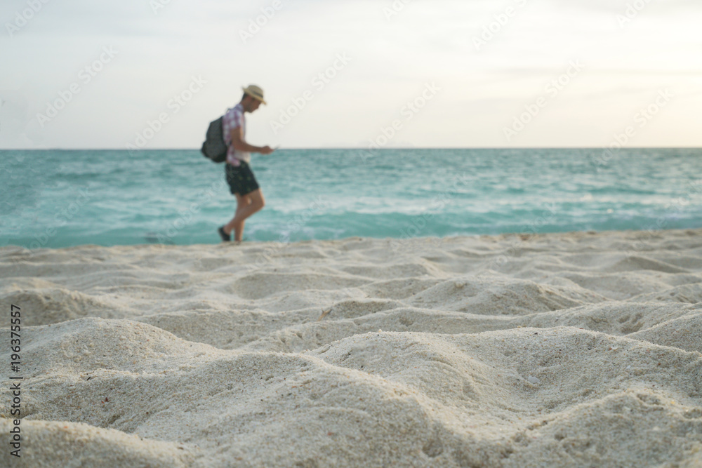 Sandy beach in morning with blurry traveler and sea background Sandy beach in morning with blurry traveler and sea background