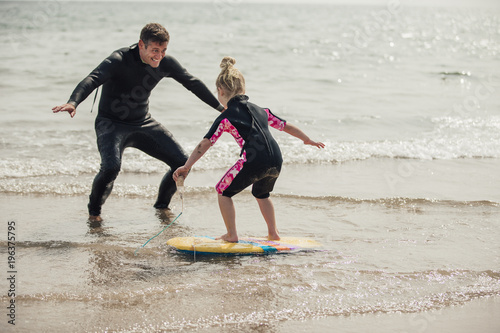 Photography Teaching a Little Girl how to Surf