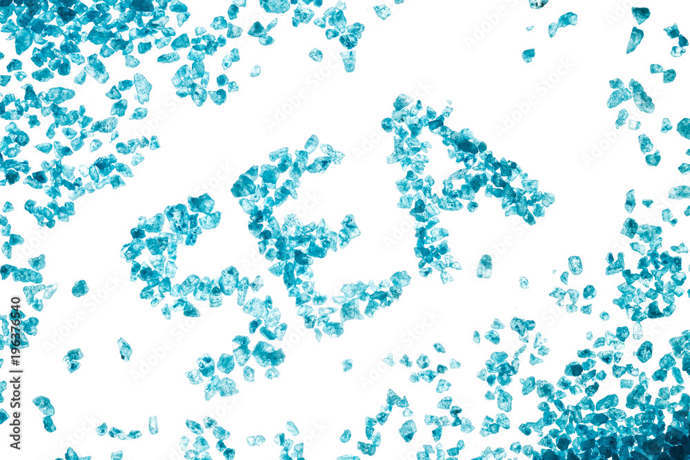 Blue crystals of sea salt and inscription SEA on white background