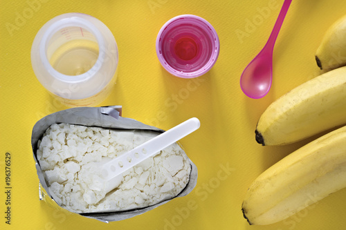 .Baby food on a yellow background, baby bottle and bananas