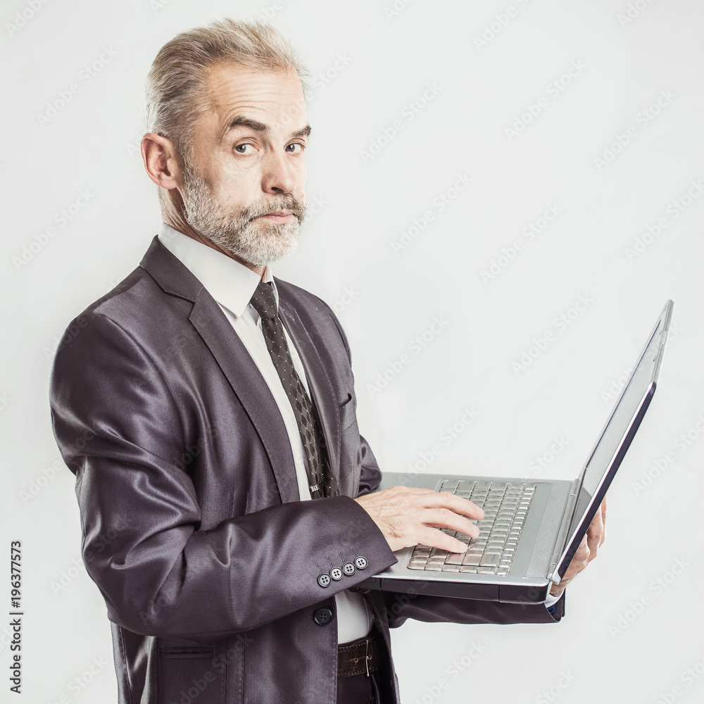 portrait in full growth - experienced businessman with an open laptop on a white background portrait in full growth - experienced businessman with an open laptop on a white background