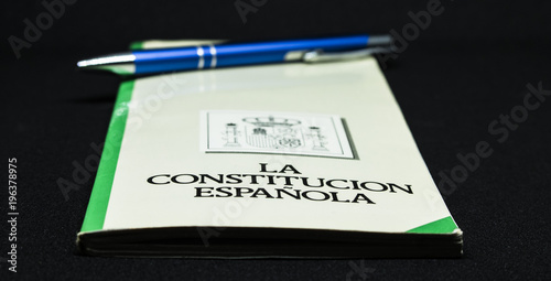 Book of the spanish constitution wiht a pen and the graphical white background