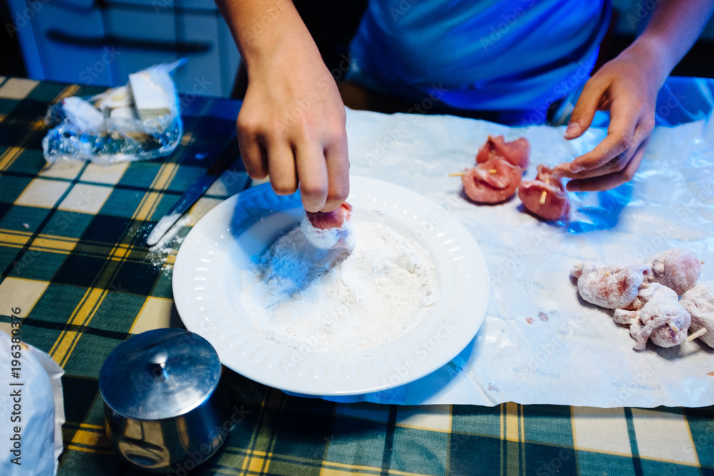 Fototapeta premium hands prepare pieces of meat, put into flour to be cooked
