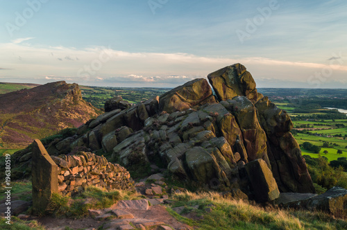 Sunset lights the heather and rocks at the Roaches, Staffordshire in the Peak District National park. hen Cloud can be viewed in the distance. photo