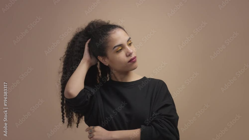 closeup woman's portrait in studio in beige background mixed race woman with curly hair closeup woman's portrait in studio in beige background mixed race woman with curly hair