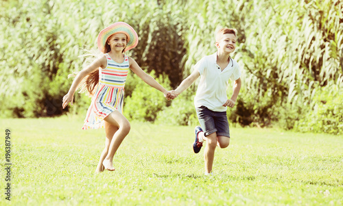 Two children running in park.